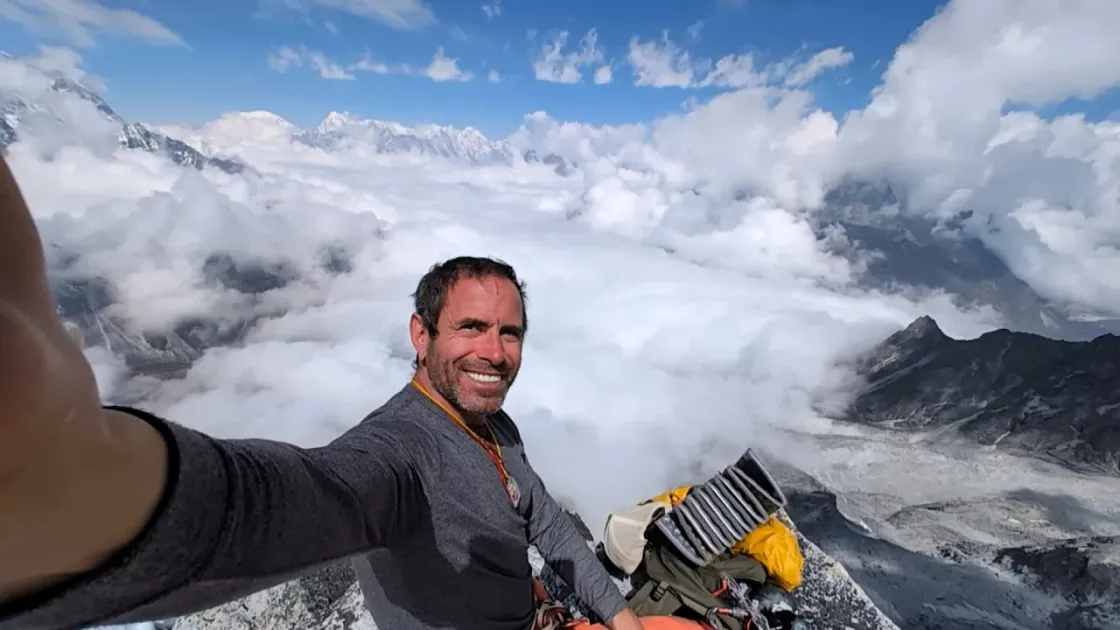 Michael Arnstein taking a mountain selfie above the clouds